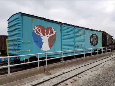 Photo of the NNYCRR Museum's teal boxcar with the logos of the City of Elkhart and the Museum painted on it. 