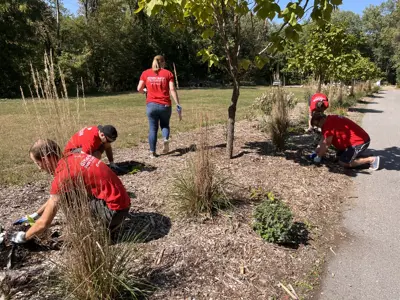 Volunteers from Lippert plant plants along River Greenway Trail