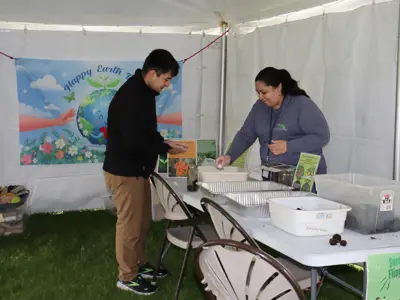 Volunteers help with recycled bubbles activity at Earth Day event at EEC