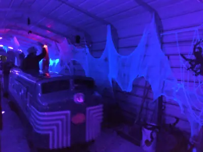 The NIBCO Century Flyer amusement train in the tunnel, decorated with black lights, webs, and Halloween decorations for the Spooktacular Express event at the NNYCRRM