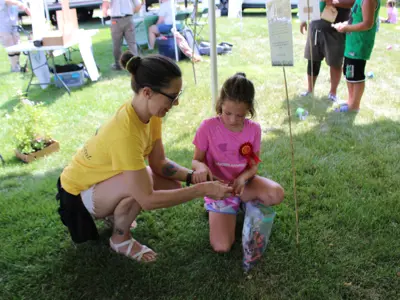 Volunteer helping with Kids Activities at Pollinator Promenade event