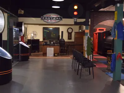 A photo of the Freight House exhibit space at the NNYCRRM. Shows the Station Master's office, part of the kids play space, and the entrance to the Uniform Room