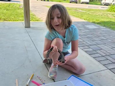 Kid holding a horse shoe at Junior Indiana Master Naturalist program at EEC