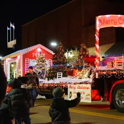 Small boy waving at the Santa float during the Winterfest lighted parade