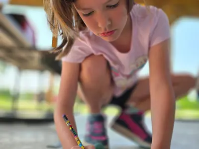 Kid writing notes at Junior Indiana Master Naturalist program at EEC