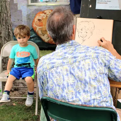 Young boy having a caricature drawn at the Rhapsody Arts & Music Festival