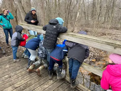 Kids looking at creek on bridge at EEC