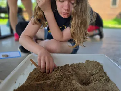 Kid digging in sandbox at Junior Indiana Master Naturalist program at EEC